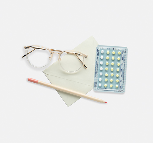 glasses, paper, contraceptives and a pencil on a desk
