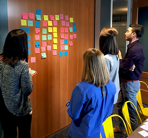 Benjamin and Bond designers and strategists working with colorful post-it notes on a wall