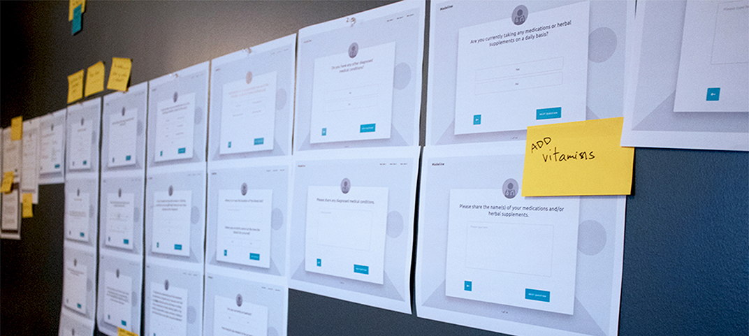 Madeline website wireframes displayed on a wall